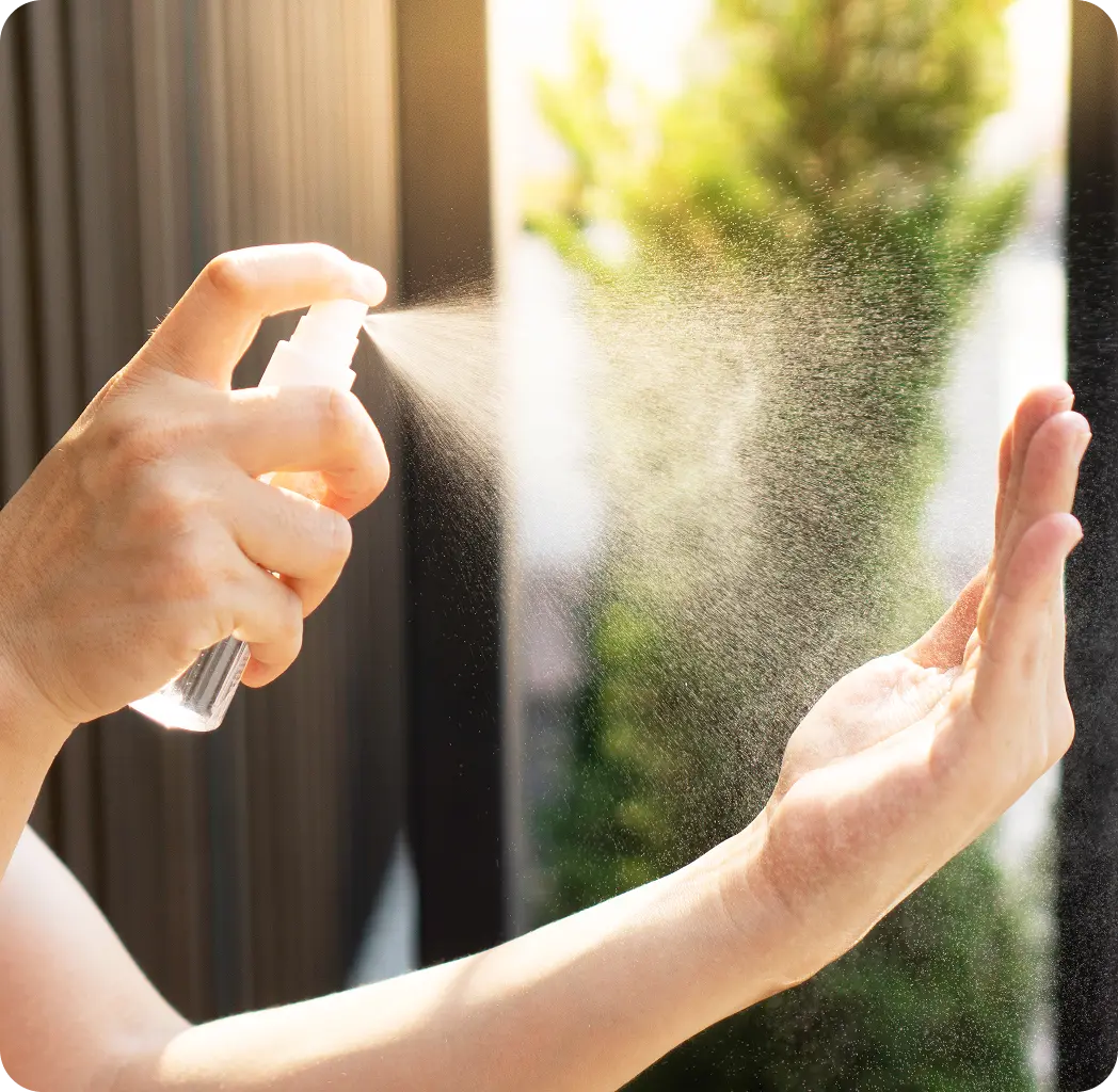Hand holding a spray bottle with mist 